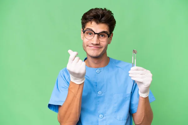 Joven Dentista Hombre Sosteniendo Herramientas Sobre Fondo Aislado Haciendo Gesto — Foto de Stock