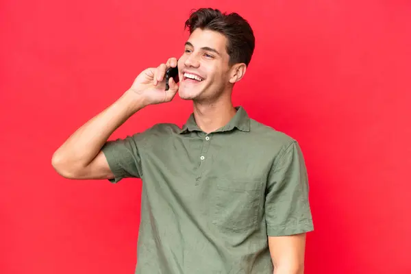 Young Caucasian Handsome Man Isolated Red Background Keeping Conversation Mobile — Stock Photo, Image