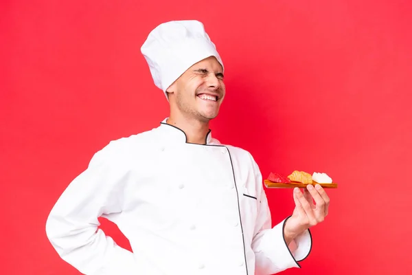 Jonge Kaukasische Chef Kok Met Sashimi Geïsoleerd Rode Achtergrond Die — Stockfoto