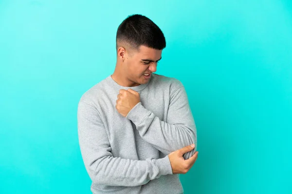 Ung Stilig Man Över Isolerad Blå Bakgrund Med Smärta Armbågen — Stockfoto