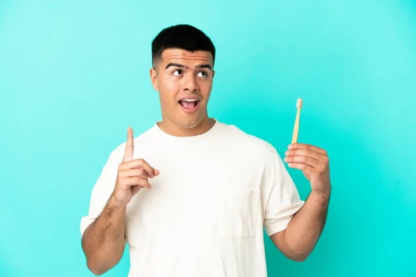 Jovem Homem Bonito Escovando Dentes Sobre Fundo Azul Isolado Pensando — Fotografia de Stock