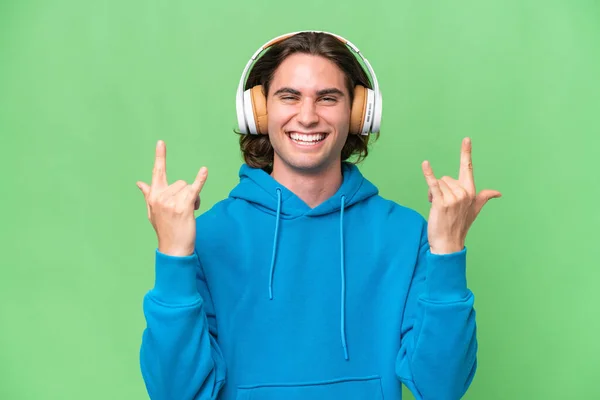 Jonge Knappe Man Geïsoleerd Groene Chroma Achtergrond Luisteren Muziek Maken — Stockfoto