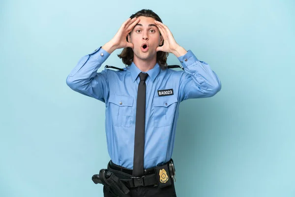 stock image Young police caucasian man isolated on blue background with surprise expression