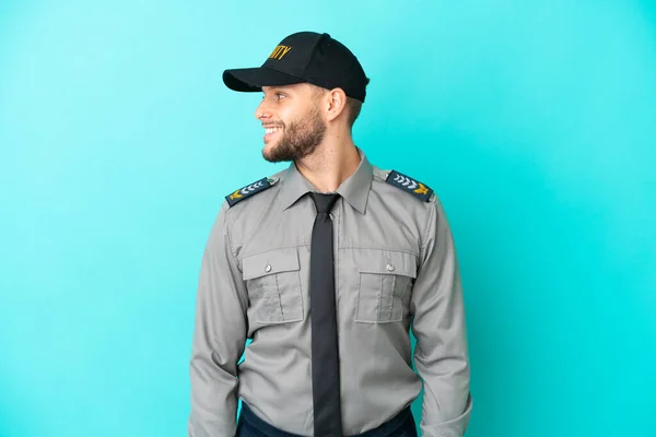 stock image Young security man isolated on blue background looking side