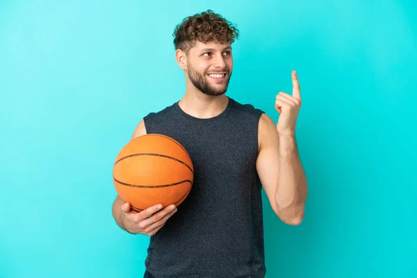 Pemuda Tampan Yang Bermain Basket Terisolasi Latar Belakang Biru Menunjukkan — Stok Foto