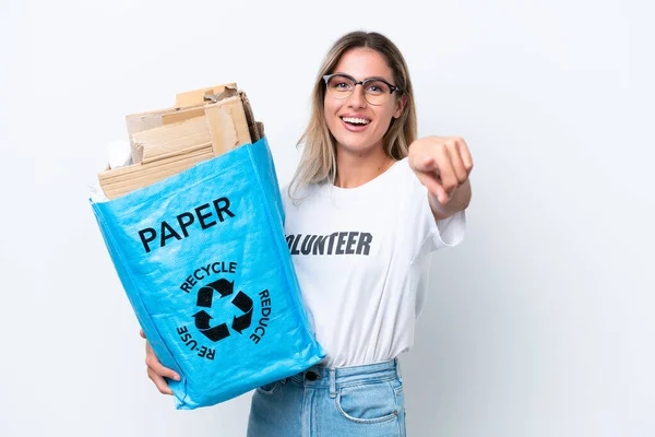 若いですかなりウルグアイの女性を保持リサイクルバッグフル紙でリサイクルするために隔離された白いクロマの背景ポイント指であなたに自信を持って式 — ストック写真