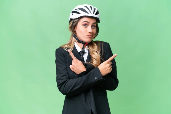 ビジネスウルグアイ女性身に着けていますヘルメットバイカー上の隔離された背景疑問を持っているラテラルを指して — ストック写真