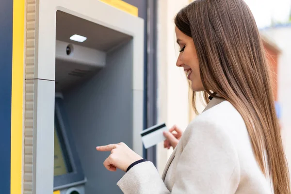 stock image Young pretty woman using an ATM