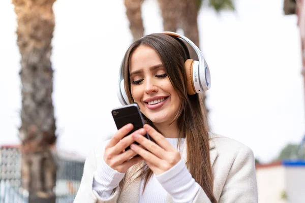 Young Pretty Woman Outdoors Listening Music Looking Mobile — Stock fotografie