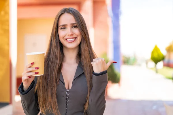 Elinde Açık Havada Kahve Tutan Genç Bir Kadın Bir Ürün — Stok fotoğraf