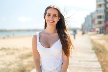 Açık havada genç bir kadın Neşeli bir ifadeyle