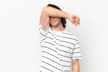 Beyaz arka planda izole edilmiş genç yakışıklı adam gözleri elleriyle kapatıyor.