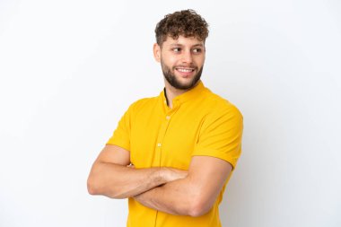 Beyaz arka planda soyutlanmış, kolları çapraz ve mutlu, yakışıklı beyaz bir adam.