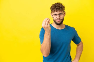 Sarı arka planda izole edilmiş yakışıklı beyaz adam İtalyan jestleri yapıyor.