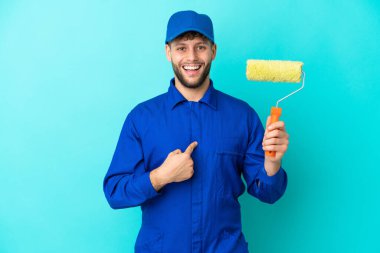 Kafkasyalı ressam mavi arka planda izole edilmiş, şaşırmış bir yüz ifadesi var.