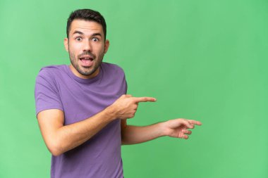 Soyutlanmış geçmişi olan yakışıklı beyaz bir adam şaşırmış ve işaret ediyor.