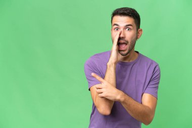 Soyutlanmış geçmişi olan yakışıklı beyaz bir adam bir ürünü sunmak ve bir şeyler fısıldamak için kenarı işaret ediyor.