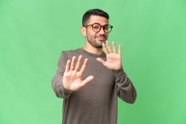 İzole edilmiş arka planda genç, yakışıklı beyaz adam ellerini öne uzatıyor.