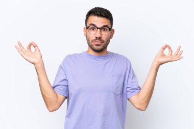 Beyaz arka planda Zen pozisyonunda beyaz tenli genç bir adam