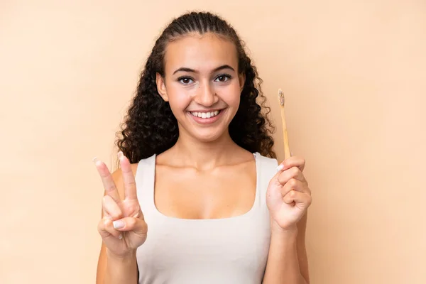 Młoda Kobieta Myje Zęby Odizolowane Beżowym Tle Uśmiechając Się Pokazując — Zdjęcie stockowe