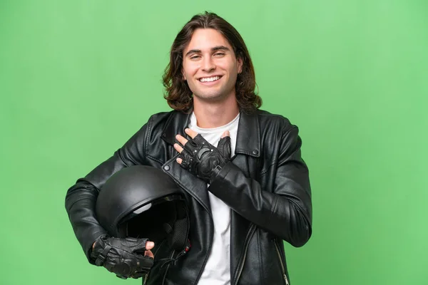 年轻英俊的男人戴着摩托车头盔 带着绿色的背景 面带微笑 — 图库照片