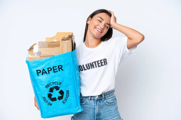 年轻的高加索女人拿着一个装满纸的回收袋 在白色的背景下进行回收 她发现了一些事情 并打算解决这个问题 — 图库照片