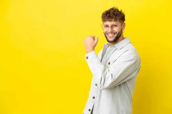 Νεαρός Όμορφος Καυκάσιος Άνδρας Απομονωμένος Κίτρινο Φόντο Γιορτάζει Μια Νίκη — Φωτογραφία Αρχείου