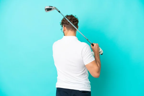 Νεαρός Όμορφος Καυκάσιος Άνδρας Απομονωμένος Μπλε Φόντο Παίζοντας Γκολφ — Φωτογραφία Αρχείου
