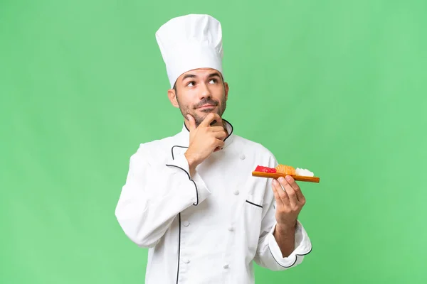 Junger Kaukasischer Koch Mit Einem Sushi Vor Isoliertem Hintergrund Und — Stockfoto