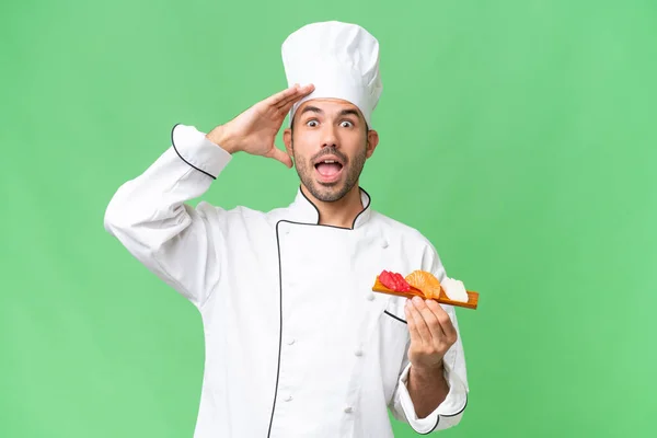 Jeune Chef Caucasien Tenant Sushi Sur Fond Isolé Avec Expression — Photo
