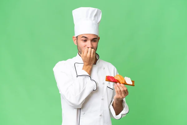 Young Caucasian Chef Holding Sushi Isolated Background Having Doubts — Stock Photo, Image
