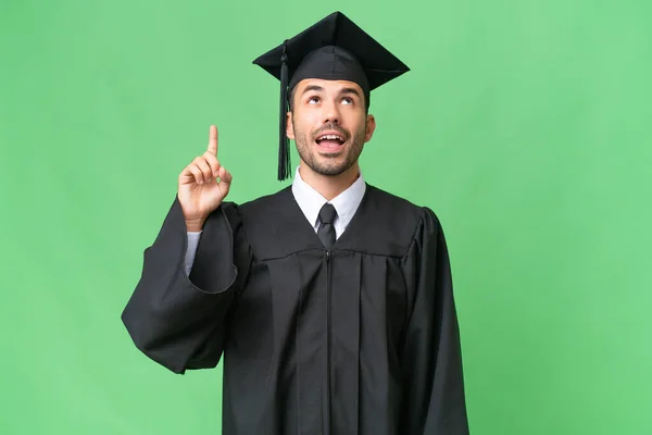 Jovem Universitário Graduado Homem Sobre Isolado Fundo Apontando Para Cima — Fotografia de Stock