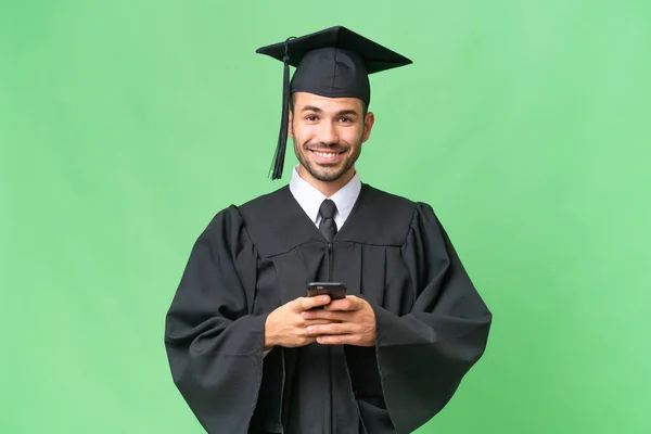 Молодой Выпускник Университета Изолированном Фоне Отправляет Сообщение Мобильного — стоковое фото