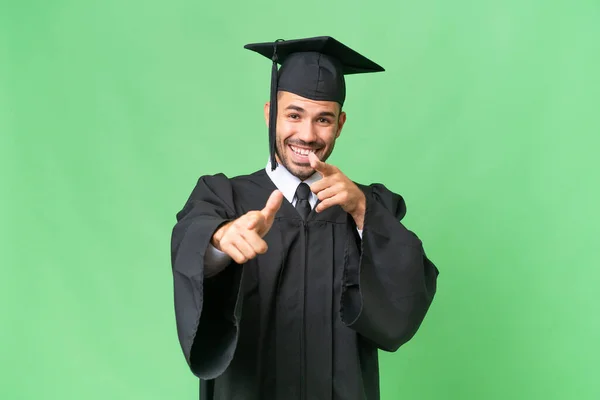 Joven Graduado Universitario Sobre Fondo Aislado Apuntando Hacia Frente Sonriendo — Foto de Stock