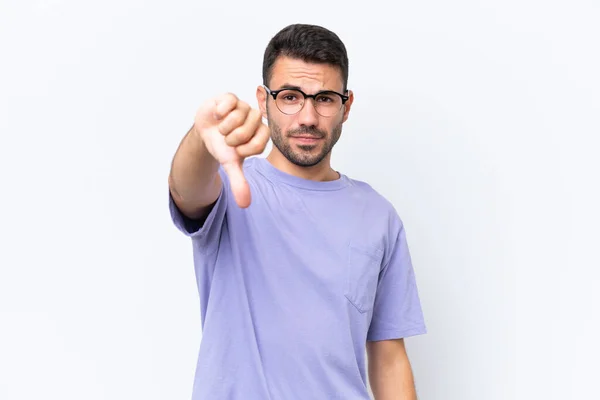 白地に孤立した若い白人男性は否定的な表現で親指を下に示す — ストック写真