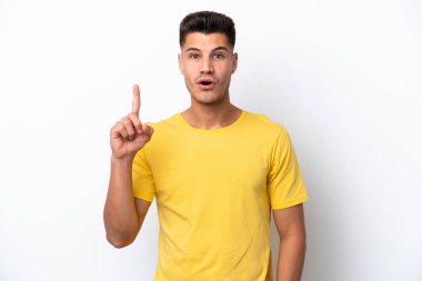 Beyaz arka planda izole edilmiş genç beyaz bir adam bir fikir düşünüyor.