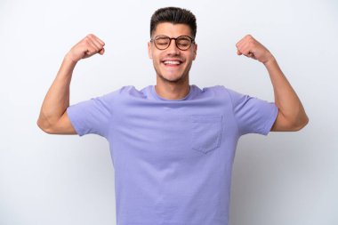 Beyaz arka planda izole genç beyaz adam güçlü jest yapıyor.
