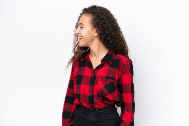 Beyaz arka planda yalnız yaşayan genç bir Arap kadın yan yana gülüyor.