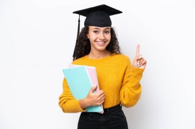 Arap üniversitesinden mezun bir kadın beyaz arka planda izole edilmiş kitapları tutuyor ve en iyinin işareti olarak parmağını kaldırıyor.