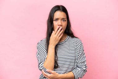 Pembe arka planda izole edilmiş genç Kolombiyalı kadın şaşırdı ve şaşırdı.