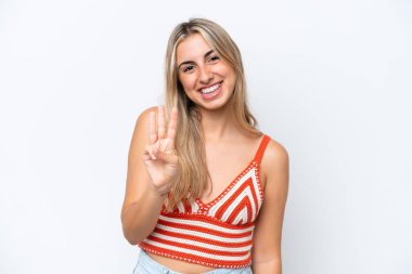 Beyaz arka planda izole edilmiş beyaz kadın mutlu ve parmaklarıyla üçe kadar sayıyor.