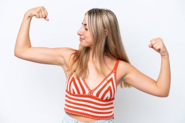 Beyaz arka planda izole genç beyaz kadın güçlü bir jest yapıyor.