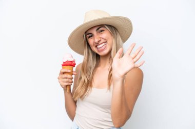 Beyaz arka planda izole edilmiş kornet dondurmalı beyaz bir kadın mutlu bir ifadeyle selamlıyor.