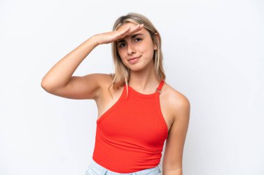 Beyaz arka planda soyutlanmış genç beyaz bir kadın, bir şeye bakmak için uzaklara bakıyor.