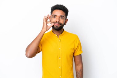 Beyaz arka planda izole edilmiş genç Brezilyalı bir adam sessizlik işareti gösteriyor.