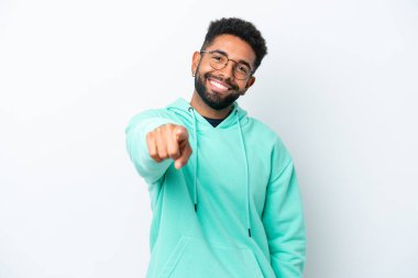 Beyaz arka planda izole edilmiş genç Brezilyalı adam mutlu bir ifadeyle öne bakıyor.