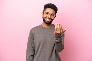 Pembe arka planda izole edilmiş genç Brezilyalı adam, bizimle gelmesi için davet ediyor. Gelmene sevindim.