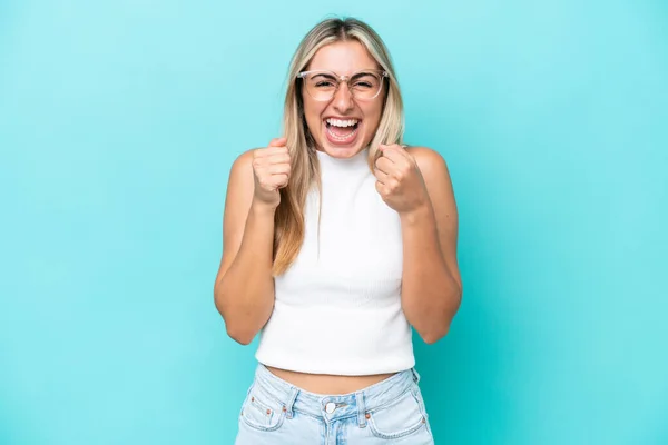 Mavi Arka Planda Izole Edilmiş Genç Beyaz Kadın Galibiyeti Kutluyor — Stok fotoğraf