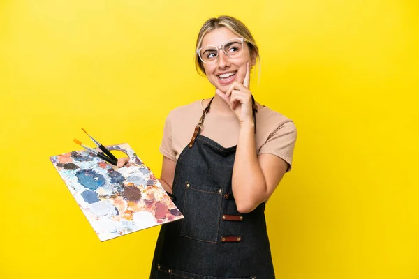 Young Artist Caucasian Woman Holding Palette Isolated Yellow Background Thinking — Stock Photo, Image