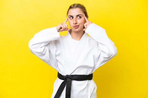 Young Caucasian Woman Doing Karate Isolated Yellow Background Having Doubts — Foto de Stock